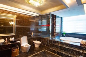 A modern bathroom with a large mirror, a bidet, a toilet, and a bathtub. - China Pearl Hotel (Dehua)