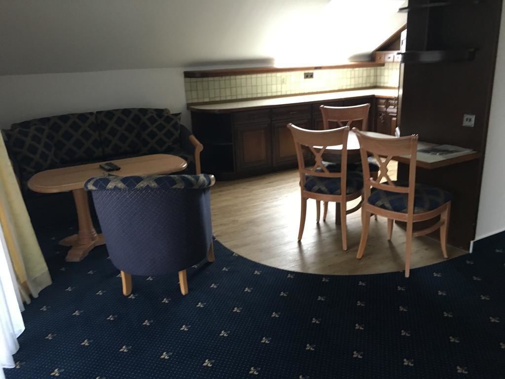 A compact living space with a kitchenette, a dining area with a table and chairs, and a sofa.