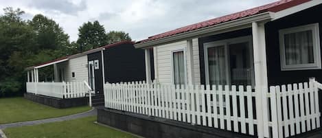 Filas de casas móviles con cercas blancas y césped.