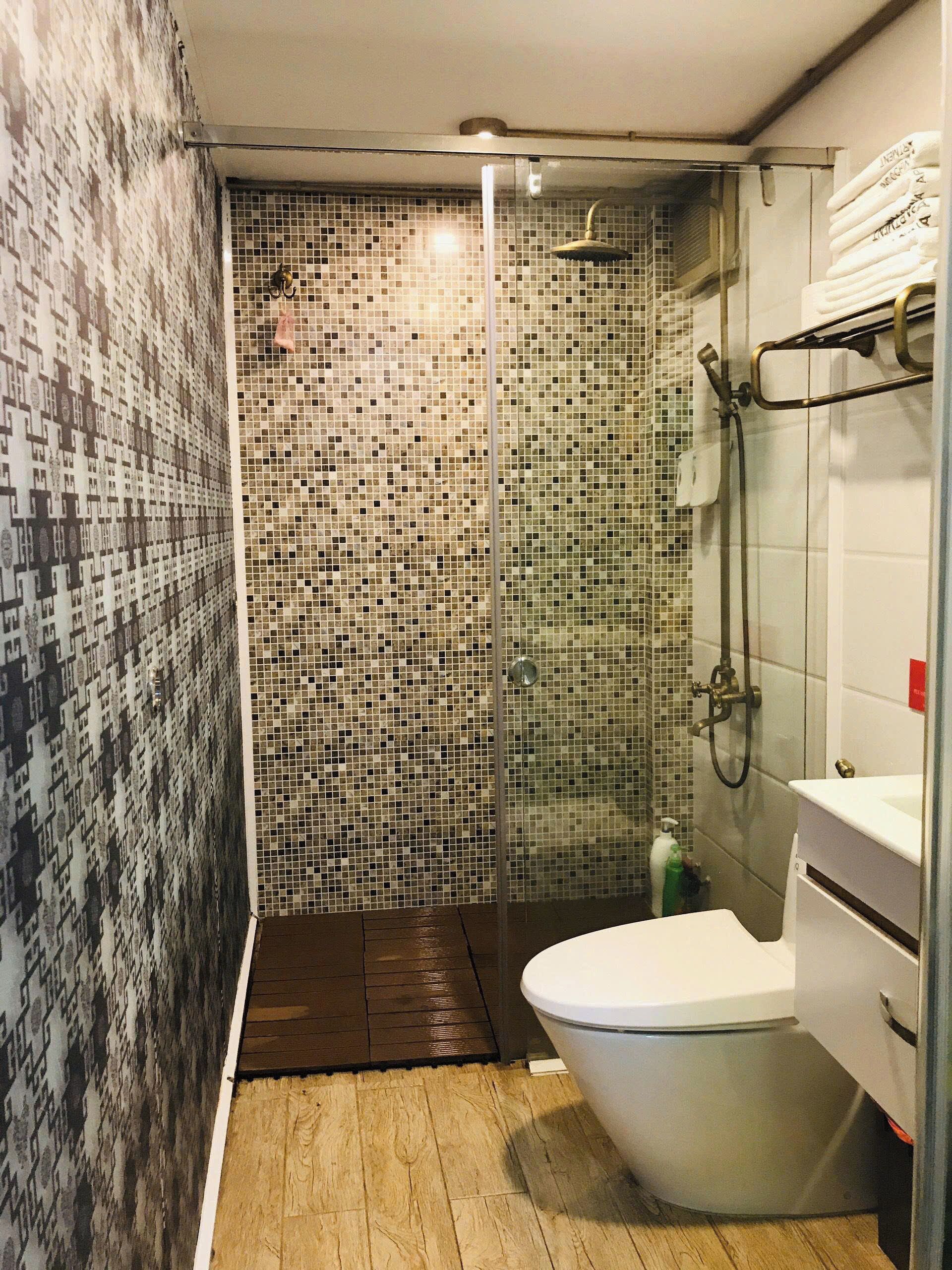 A bathroom with a shower, a toilet, and a sink.