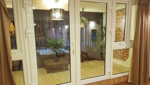 A room with a sliding glass door leading to a patio area. - Indochine Ben Thanh Hotel & Apartments (Ho Chi Minh City)