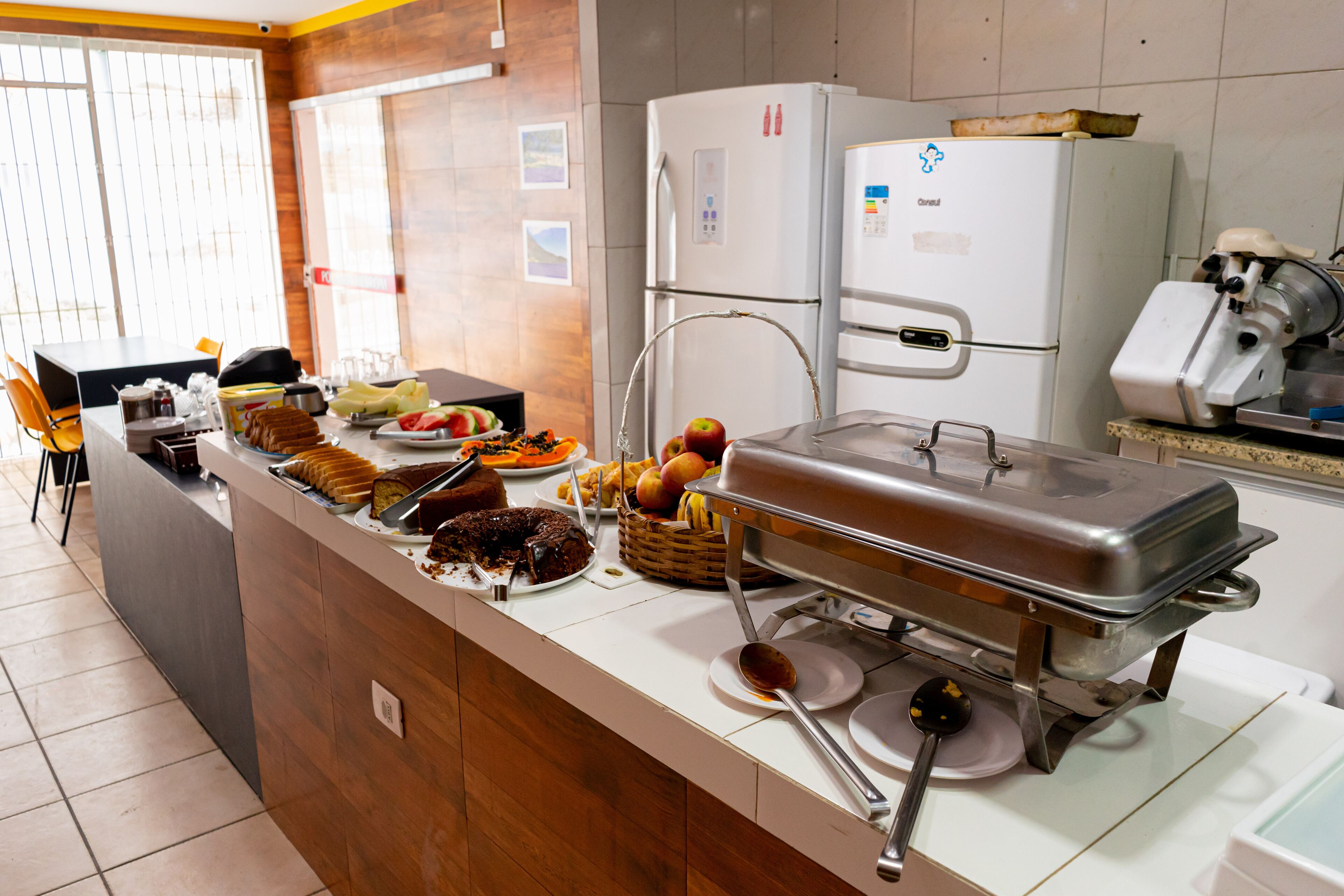 A buffet setup with various dishes, a refrigerator, and a microwave.