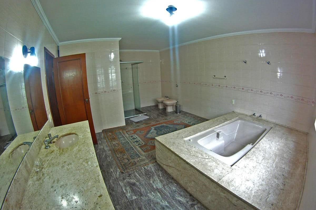 A bathroom with a large bathtub, a sink, and a shower.