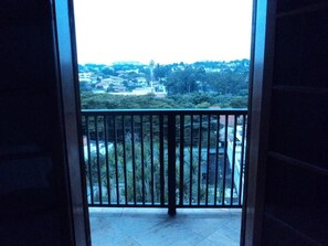 A balcony with a metal railing overlooking a residential area with houses and greenery. - Plaza Morumbi (São Paulo)