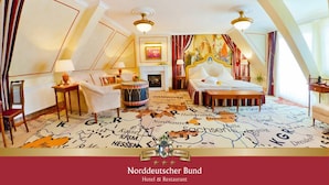 A hotel room with a bed, a chair, a small table, a lamp, a map-themed carpet, and a painting on the wall. - Hotel & Restaurant Norddeutscher Bund (Heilbad Heiligenstadt)