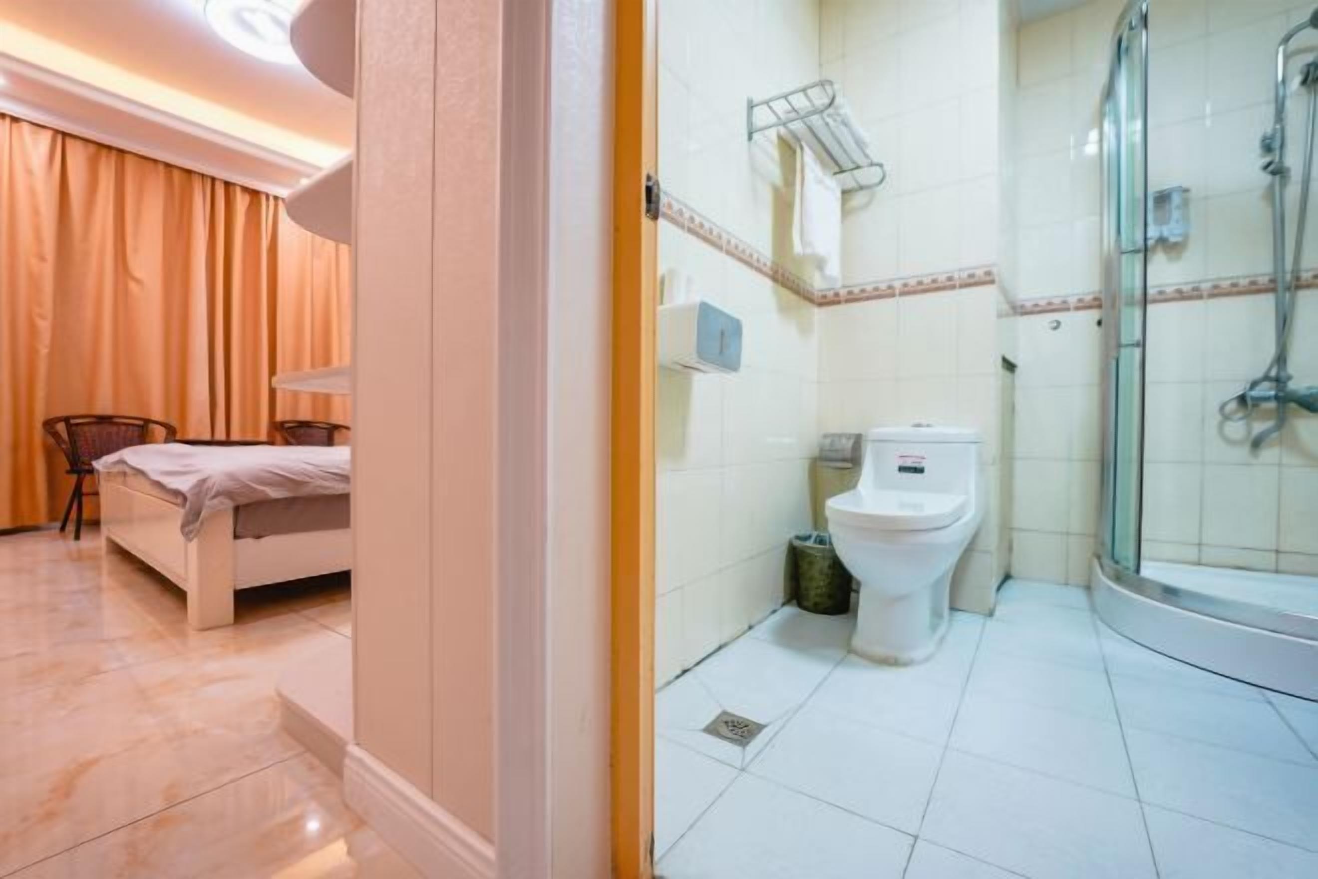 Una habitación de hotel con cama, ducha y baño.