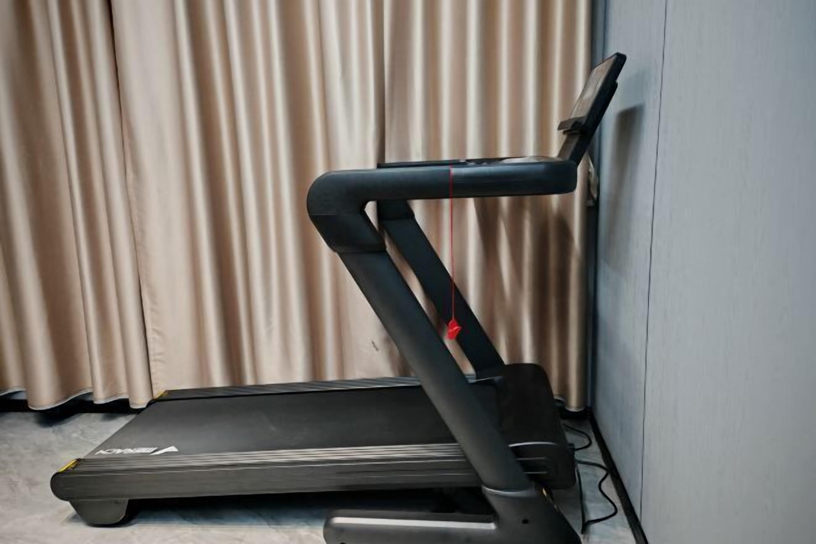 Una cinta de correr en una habitación con un telón de fondo.