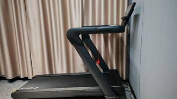 Una cinta de correr en una habitación con un telón de fondo.