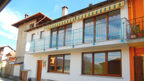 A two-story building with a balcony, large windows, and potted plants. - Le Colline di Maggiora (Maggiora)
