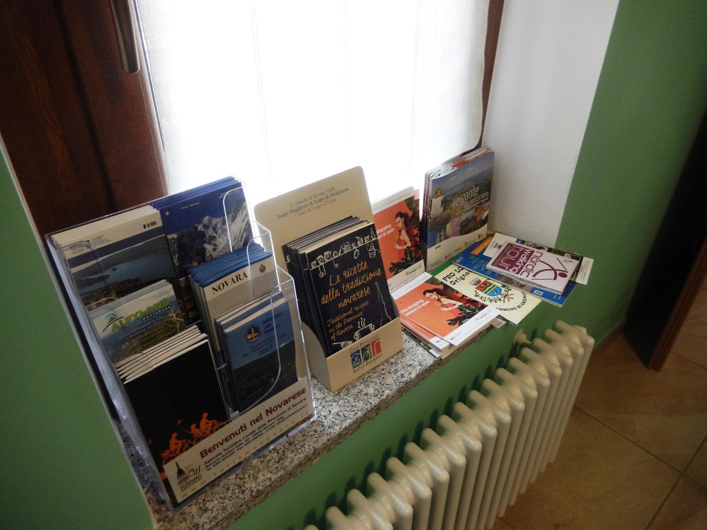 Exposição de folhetos e livros sobre um balcão, com um radiador abaixo.
