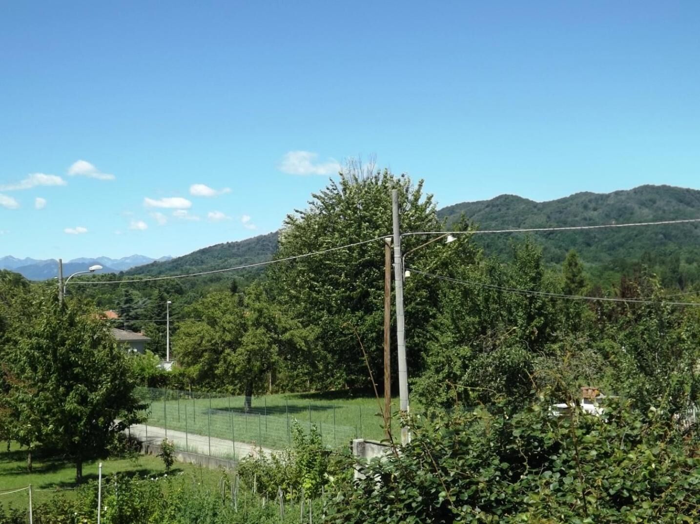 Paesaggio rurale con cielo sereno, una strada e una recinzione.