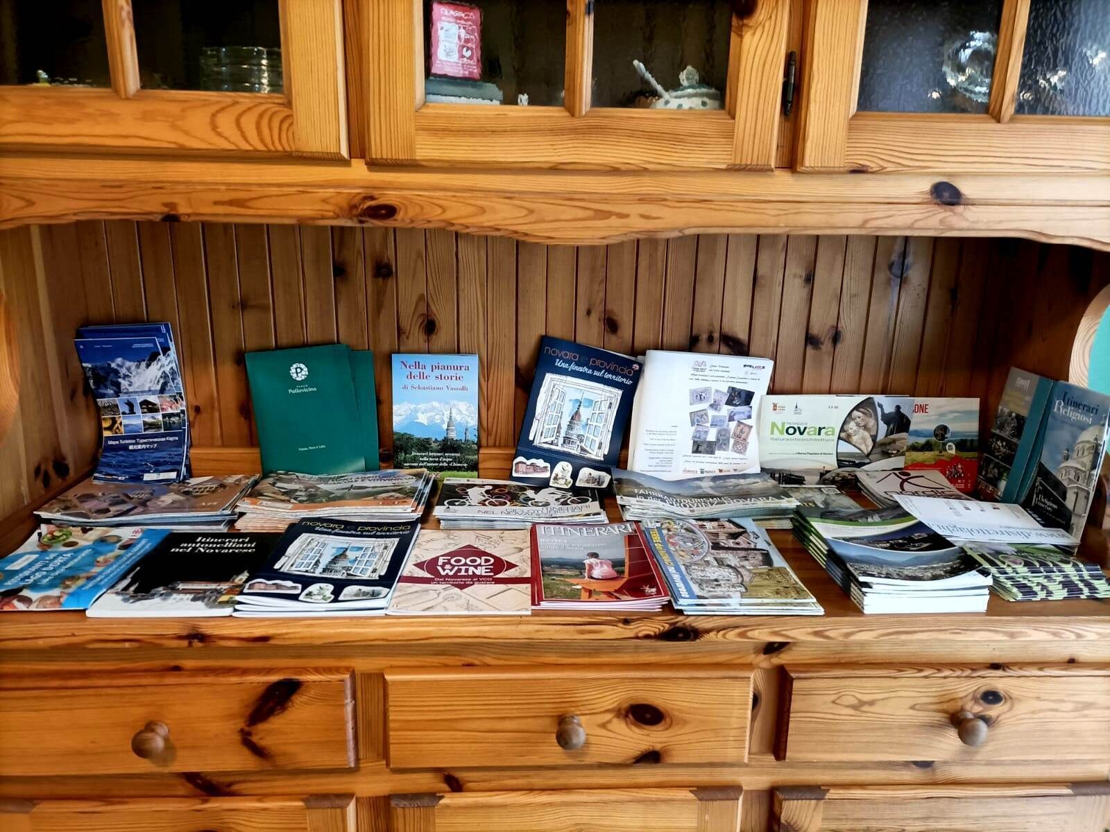 A wooden display case with various travel and food-related books and magazines.