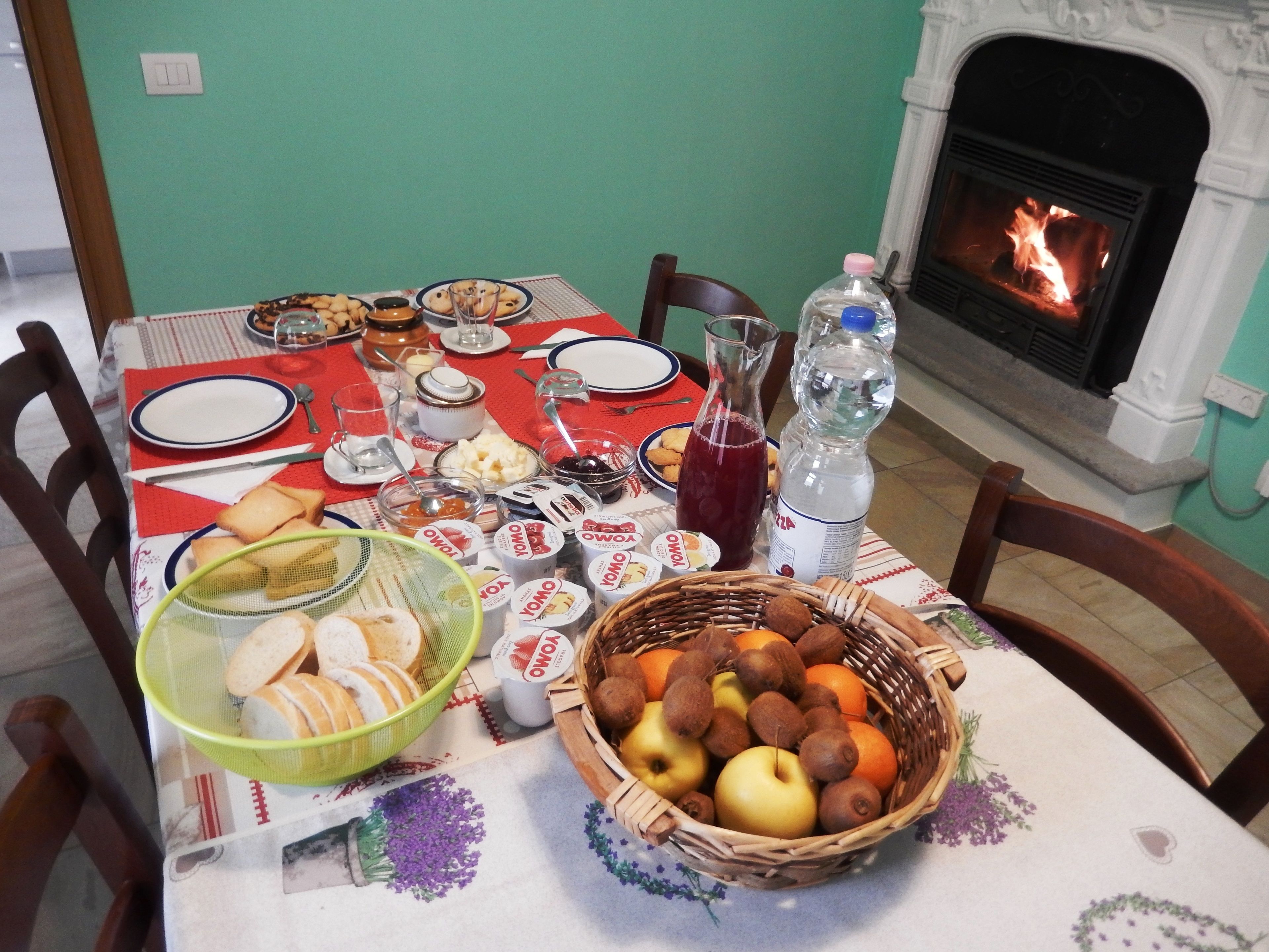 Une table à manger dressée avec divers plats, une carafe et une bouteille d’eau.