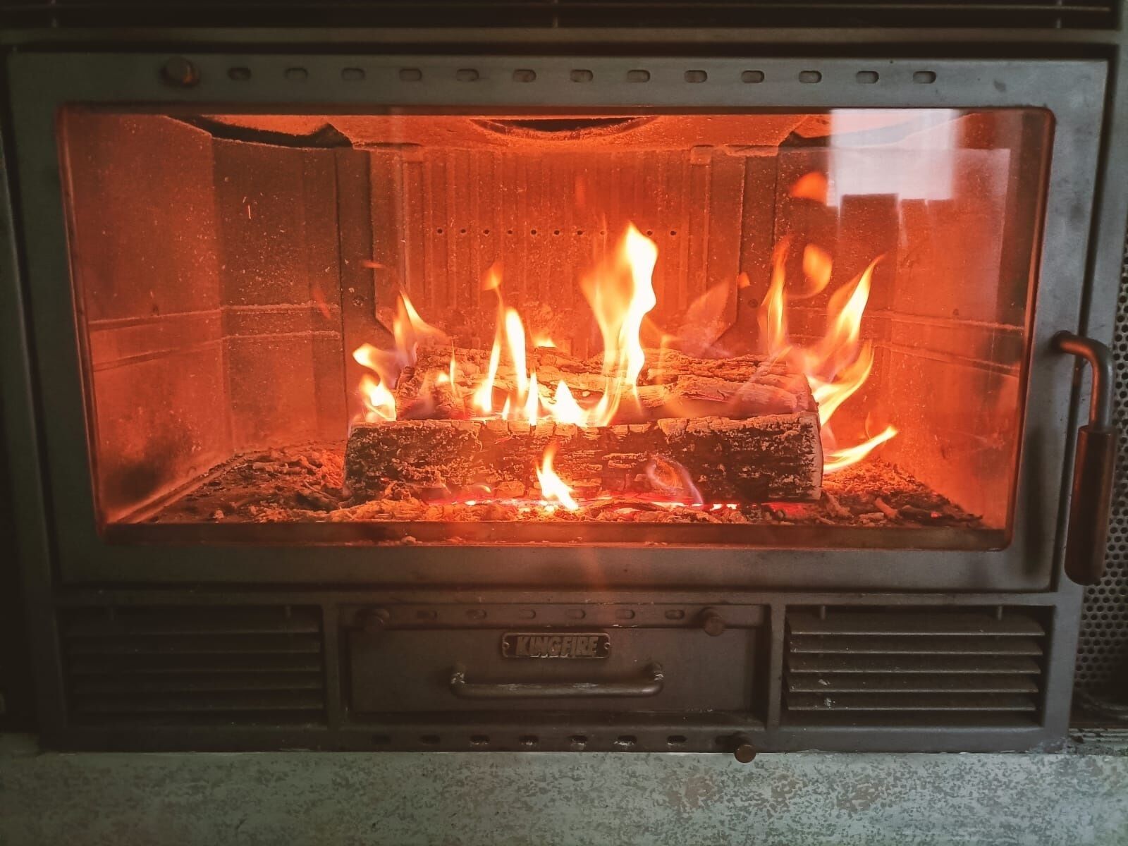 Un poêle à bois dont on peut voir les flammes et les bûches.