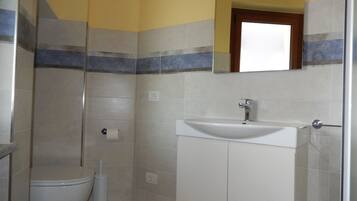 Un bagno con il water, un lavandino e una doccia.