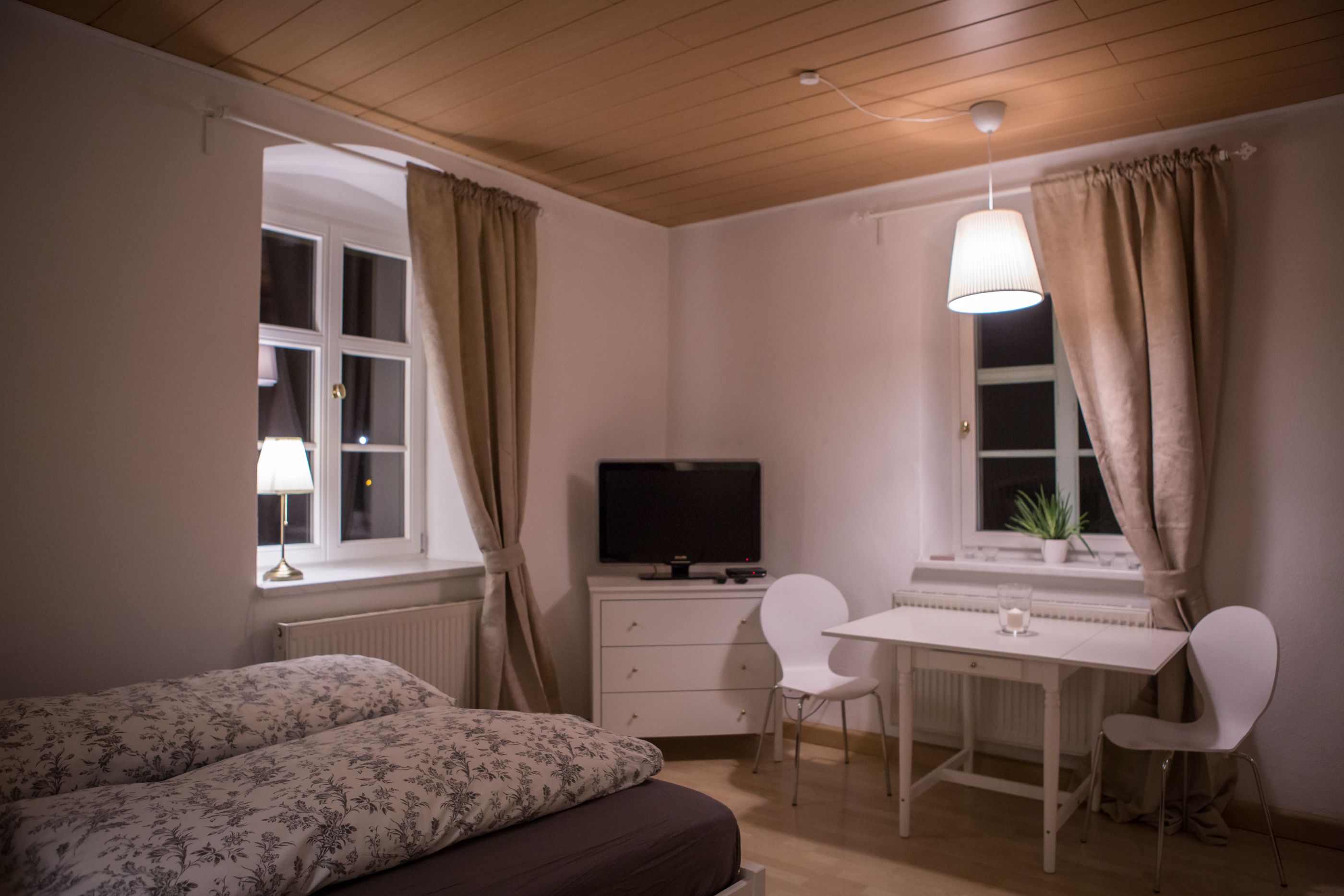 Ein Schlafzimmer mit Bett, Schreibtisch und Fernseher.