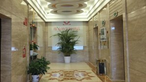 A hotel lobby with a modern ceiling design, a reception desk, and a large potted plant. - Vienna Classic Hotel (Shangrao Pedestrian street Peace Sunshine) (Shangrao)
