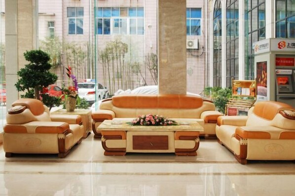 A lobby with a sofa set, a coffee table, and a small plant arrangement.