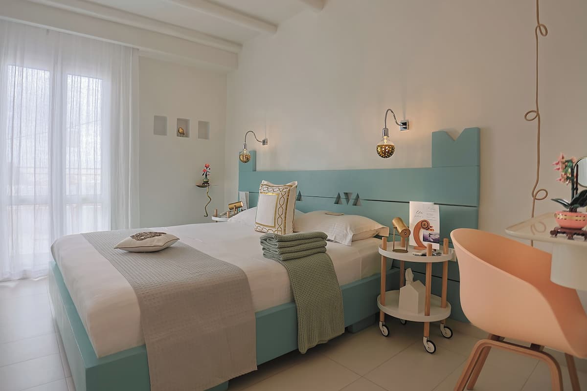 Un dormitorio moderno con cama, mesitas de noche, una silla y apliques decorativos.