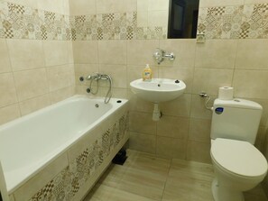 A bathroom with a bathtub, sink, and toilet.
