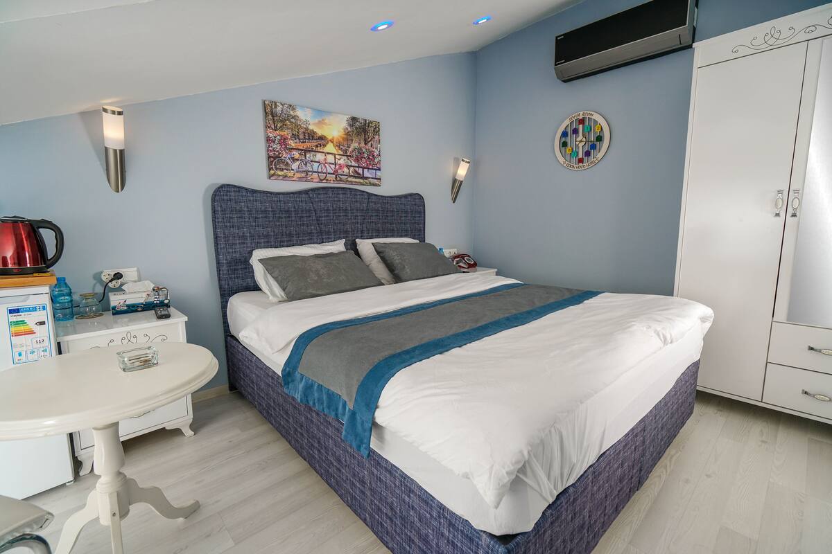 A neatly arranged bedroom with a bed, bedside table, and a wardrobe.