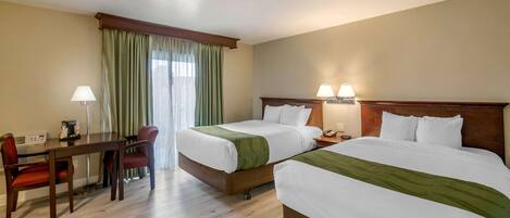 Una habitación de hotel con dos camas, un escritorio y una silla.