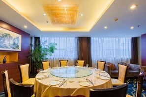 A conference room with a round table, chairs, and a chandelier.