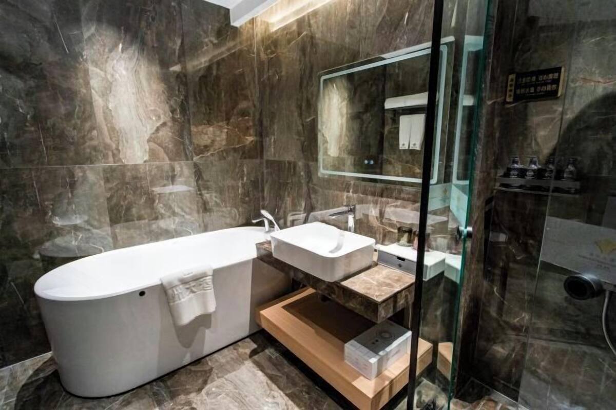 A modern bathroom with a freestanding bathtub, a vanity with a mirror, and a glass-enclosed shower area.