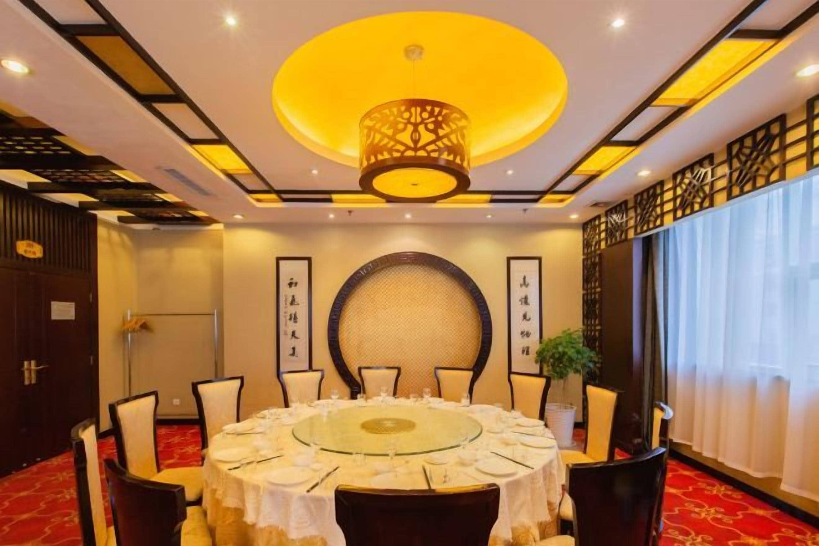 A conference room with a round table, chairs, and a chandelier.