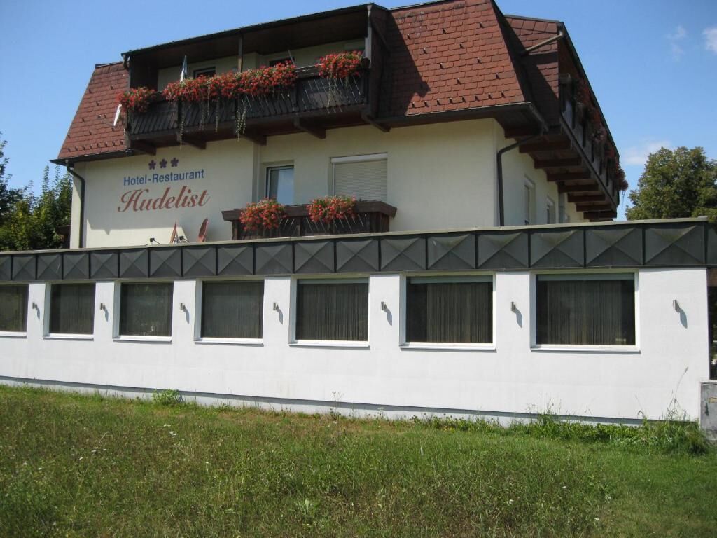 A two-story building with a sign reading "Hotel-Restaurant Hudelist."
