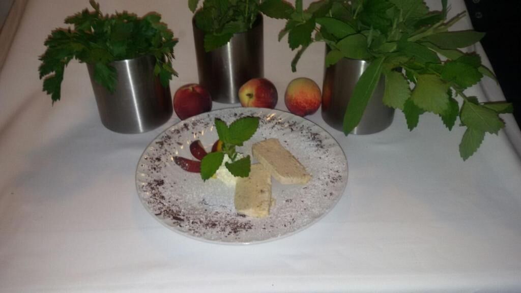 Un plato con alimentos y tres macetas de metal con plantas.