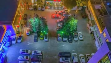 An aerial view of a parking lot with cars and trees.