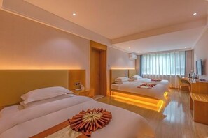 A hotel room with two beds, a desk, a chair, and a large window with curtains. - Suzhou Hotel (Jiuquan)