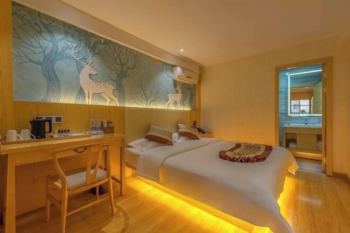 Ein Hotelzimmer mit Bett, Schreibtisch und einem großen Spiegel.