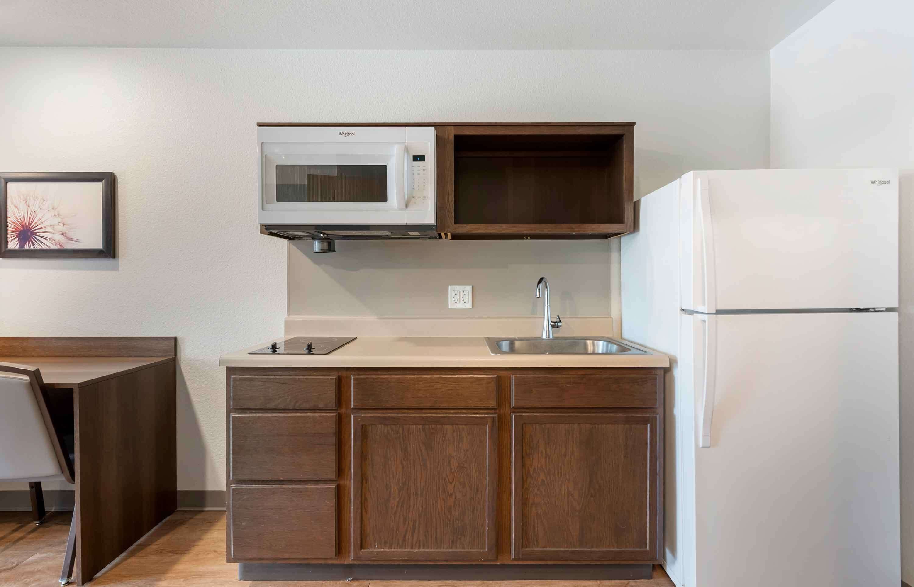 A compact kitchen with a microwave, sink, and refrigerator.