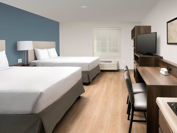 A hotel room with two beds, a desk, a chair, a television, and a window with blinds. - Extended Stay America Suites - Portland - East (Portland)