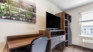 A modern room with a desk, chair, TV, and built-in shelving. - Extended Stay America Suites - Portland - East (Portland)
