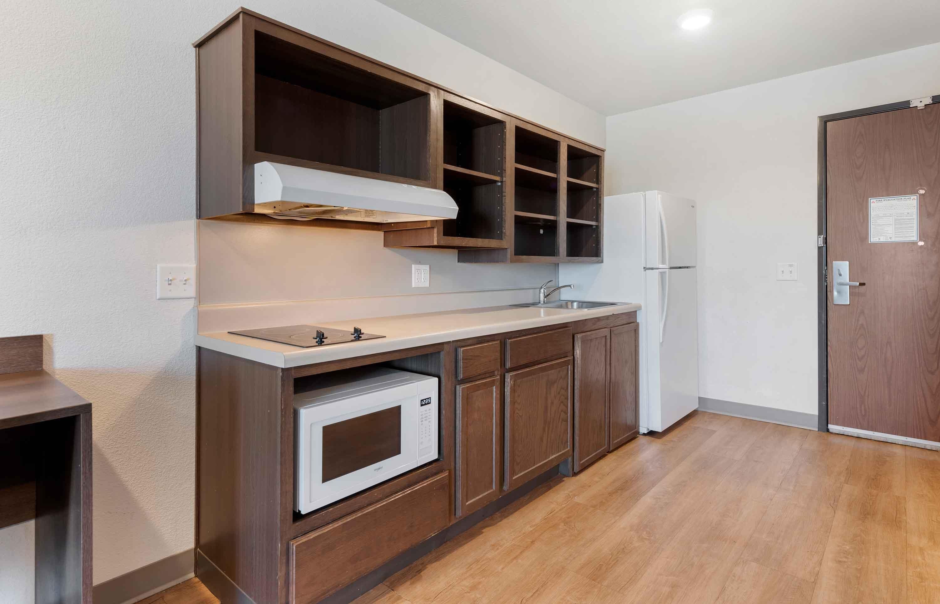 Una cocina compacta con horno integrado, microondas, lavaplatos y refrigerador.
