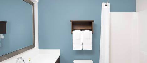 A bathroom with a white sink, a toilet, and a shower curtain.