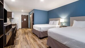 A hotel room with two beds, a desk with a chair, a wardrobe, and a door leading to another room. - WoodSpring Suites Harrisburg Linglestown (Harrisburg)