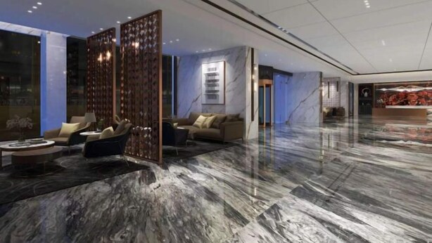 Un vestíbulo amplio con piso de mármol, zona de estar con sofás y un separador decorativo.