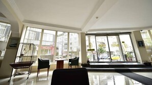 A hotel lobby with large windows, a reception desk, and a seating area. - Topkapi Hotel (Istanbul)