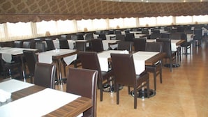 A large dining hall with multiple tables and chairs, arranged in rows. - Topkapi Hotel (Istanbul)