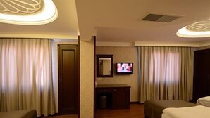 Una habitación de hotel con dos camas, televisión y escritorio.