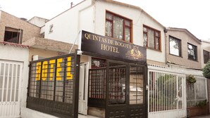 Ein Hotel namens "Quintas de Bogota Hotel" mit einem Schild, einem verschlossenen Eingang und einem weißen Zaun.