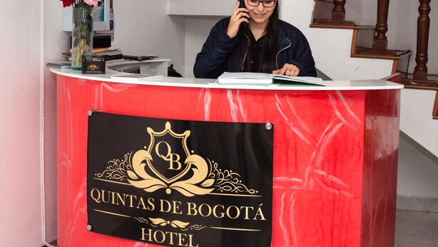 Ein Empfangstresen mit einem Schild, das 'Quintas de Bogota Hotel' zeigt.