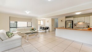 Uma sala de estar moderna com sofá, mesa de centro e área de jantar.