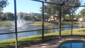 Una piscina con vista despejada a una fuente y un lago al fondo.
