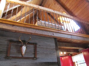 Staircase leads to a cozy living space with a mounted animal skull on the wall.
