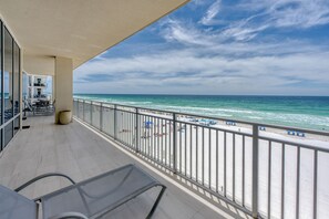 A balcony with a view of the beach and ocean.